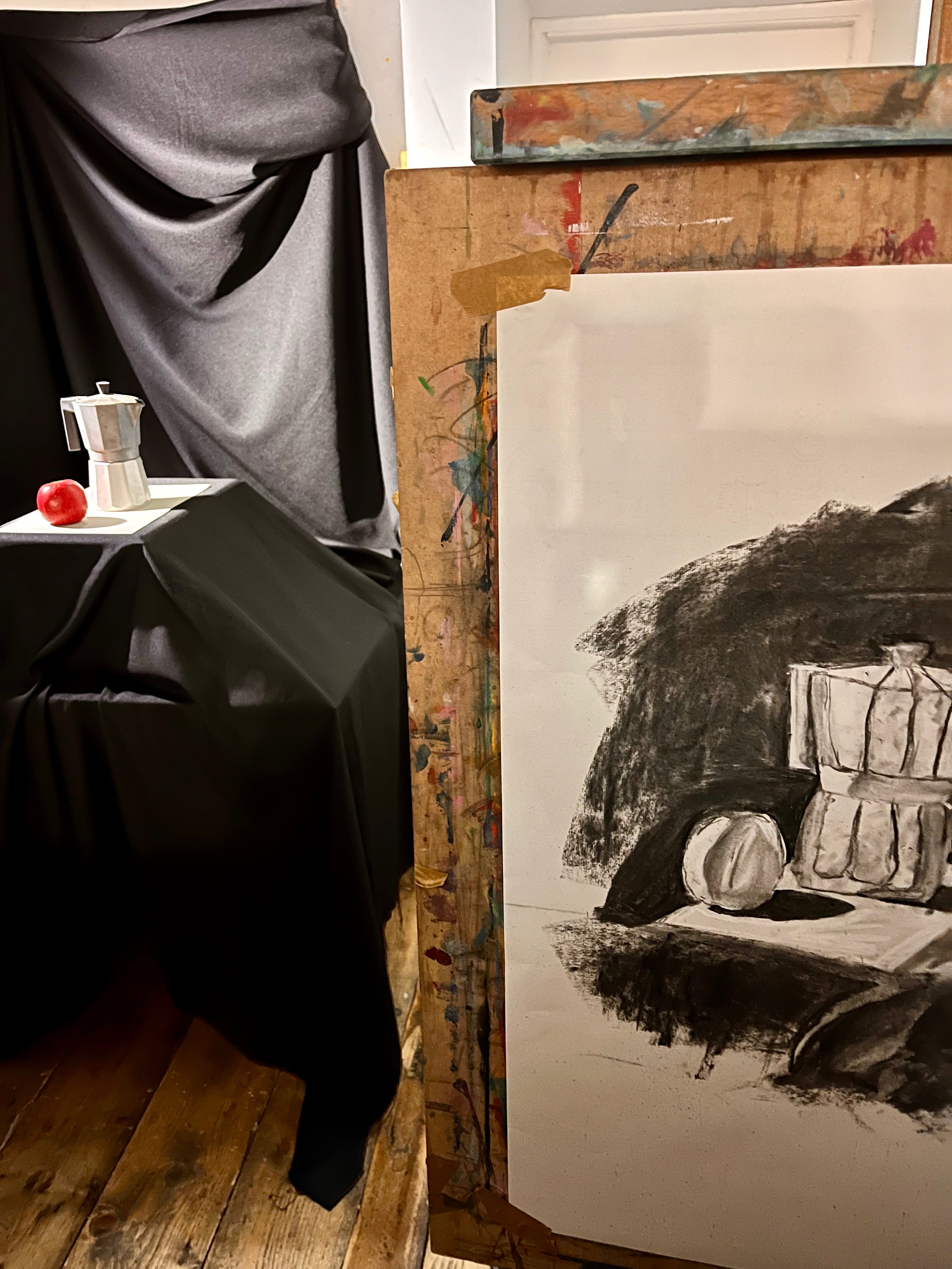 Artistic still life setup with a painting and a black curtain. Drawing a Moka Pot with a Red Apple.