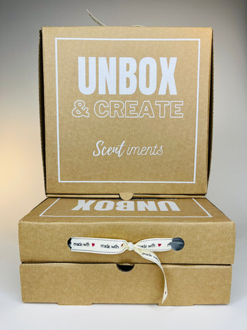 A stack of three brown cardboard boxes with white lettering and a ribbon tied around the middle box.