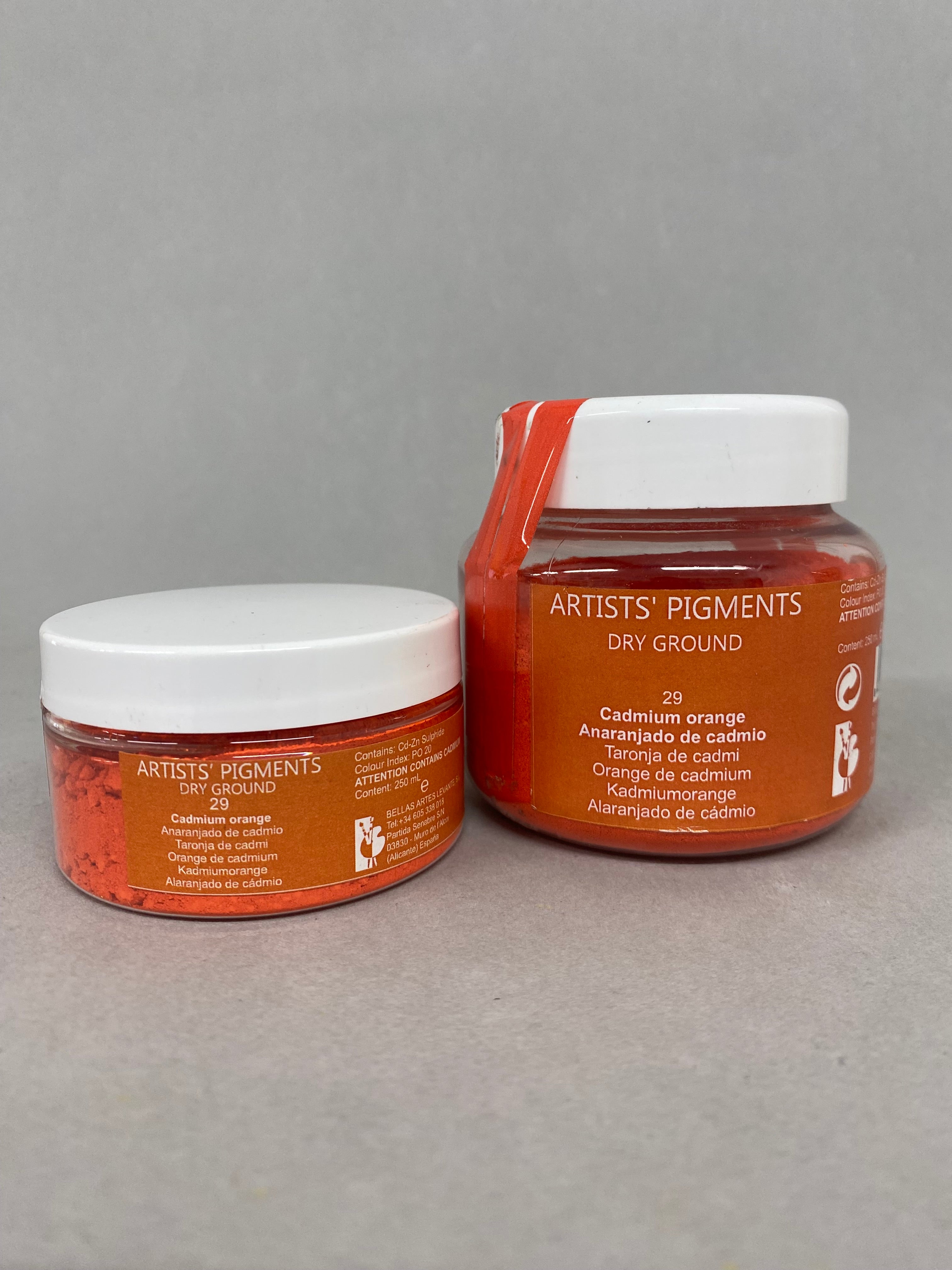 Two jars of Artist's Pigments Dry Ground on a gray background