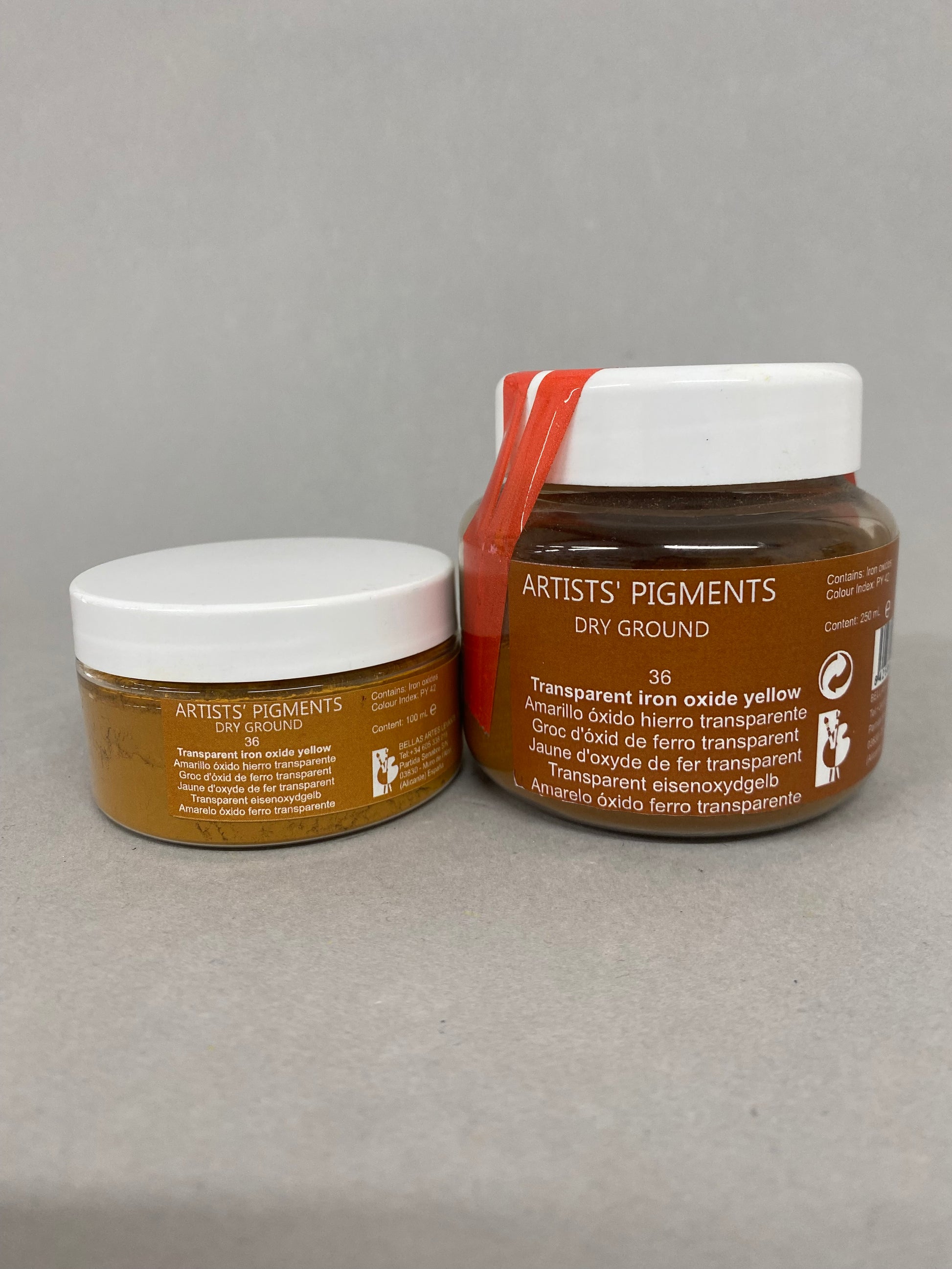 Two jars of 'Artist's Pigments' on a gray background