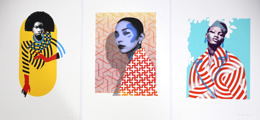 Three colorful abstract art prints on a wooden surface