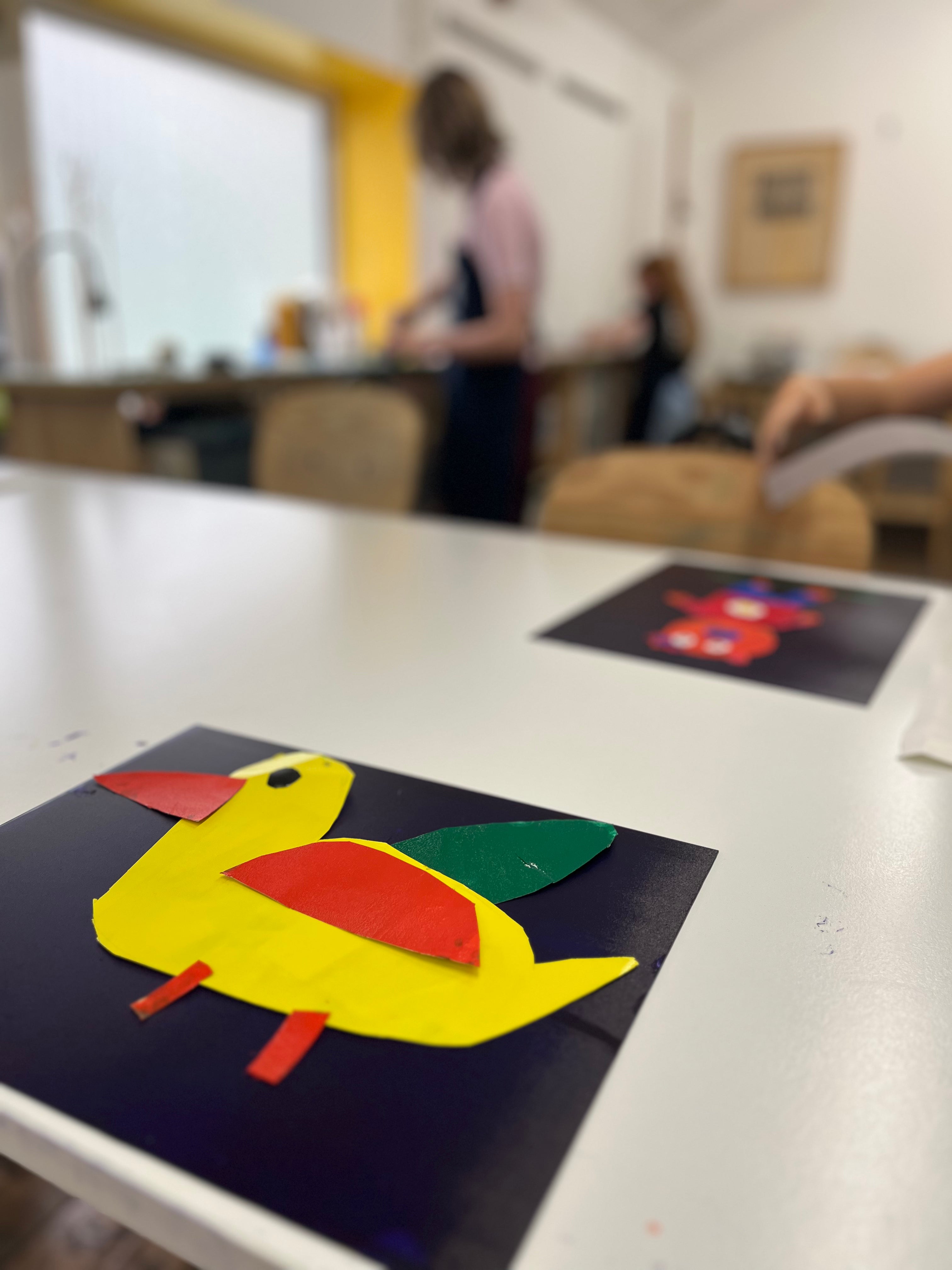 Colourful paper printmaking cut out of a duck on a table with a blurred background