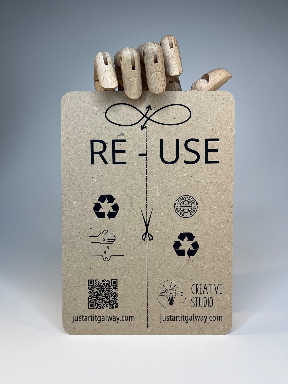 Close-up of a black notebook with a brown recycled paper cover featuring the word "DUAL" and sustainability information.