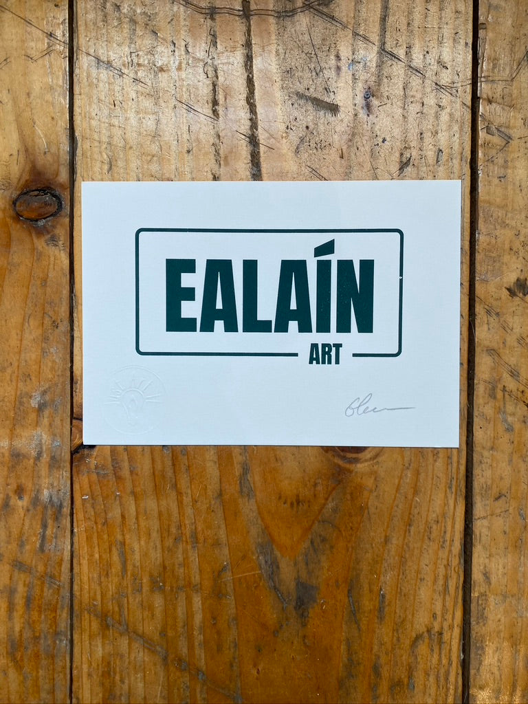 White paper with 'EALAñ ART' text on a wooden surface