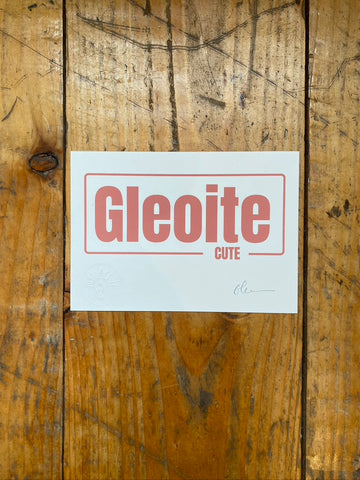 screen print on white paper with 'Gleoite' printed on it against a wooden background
