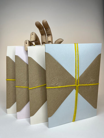 Four colorful envelopes with a hand made of wood.