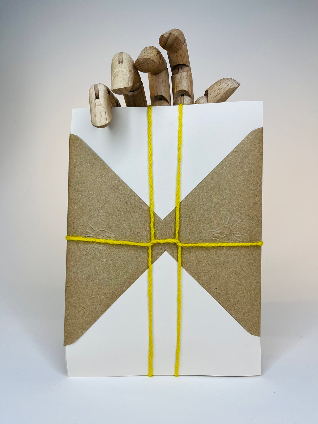 Four colorful envelopes with a hand made of wood.