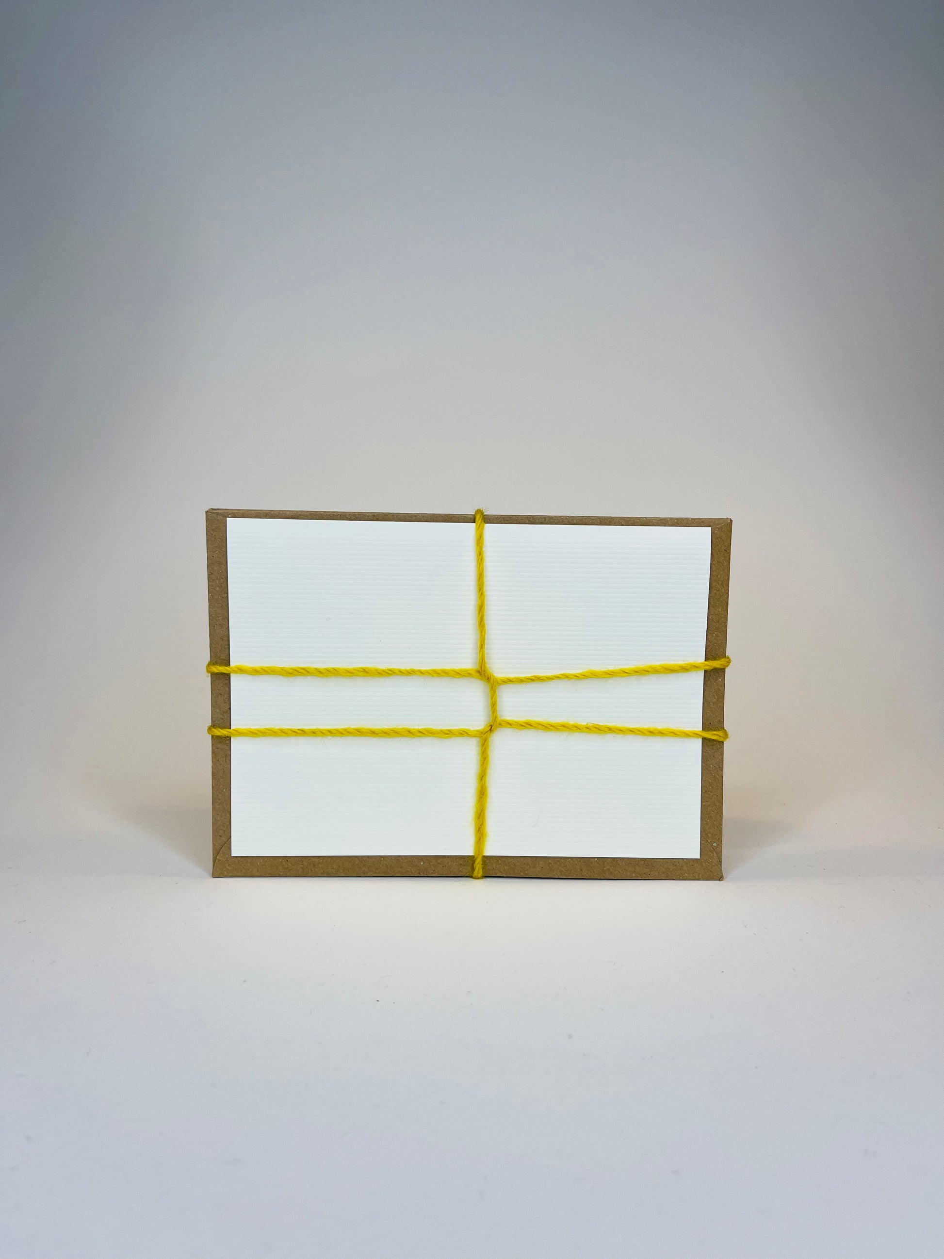 Brown box with white label and yellow yarn.