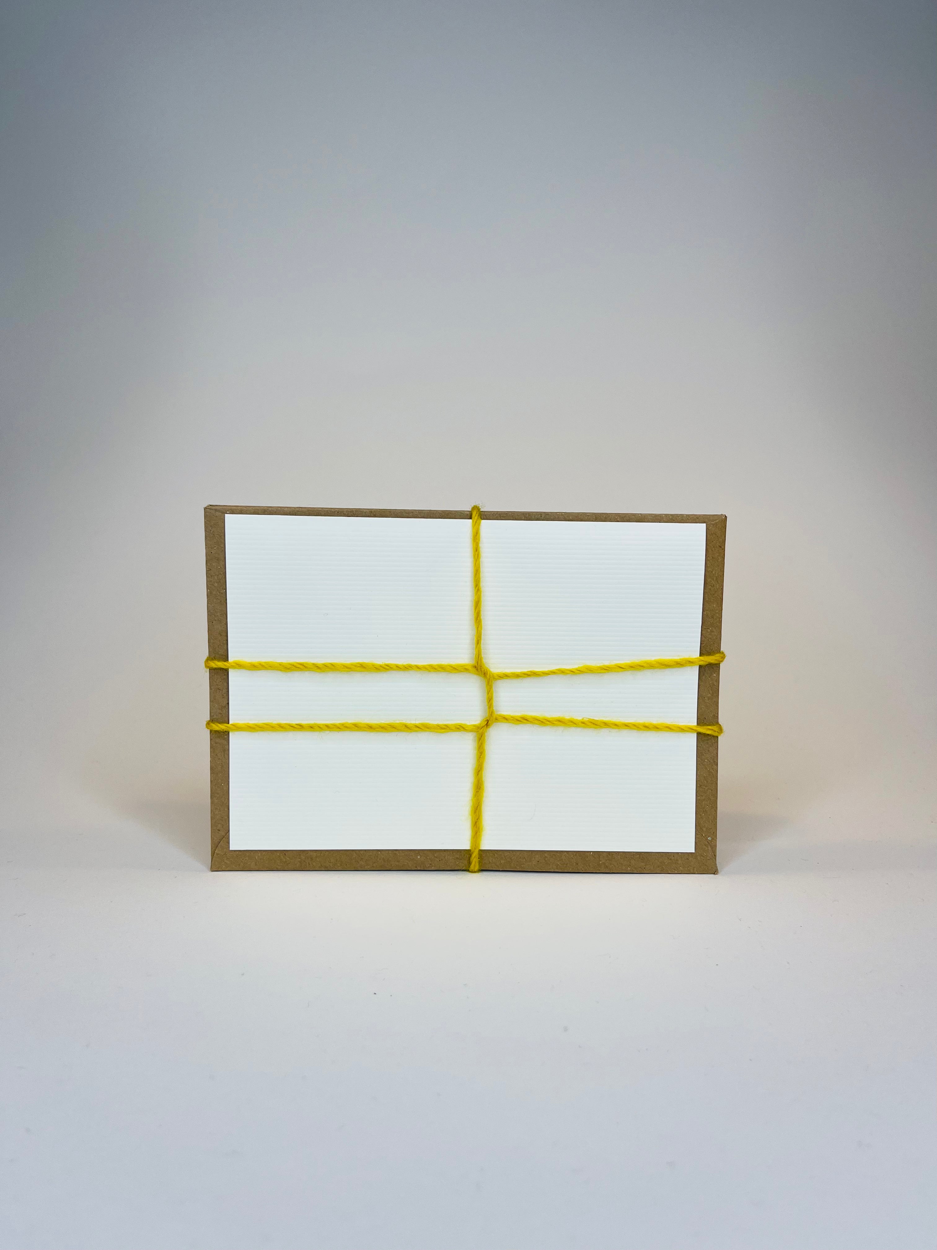 Brown box with white label and yellow yarn.