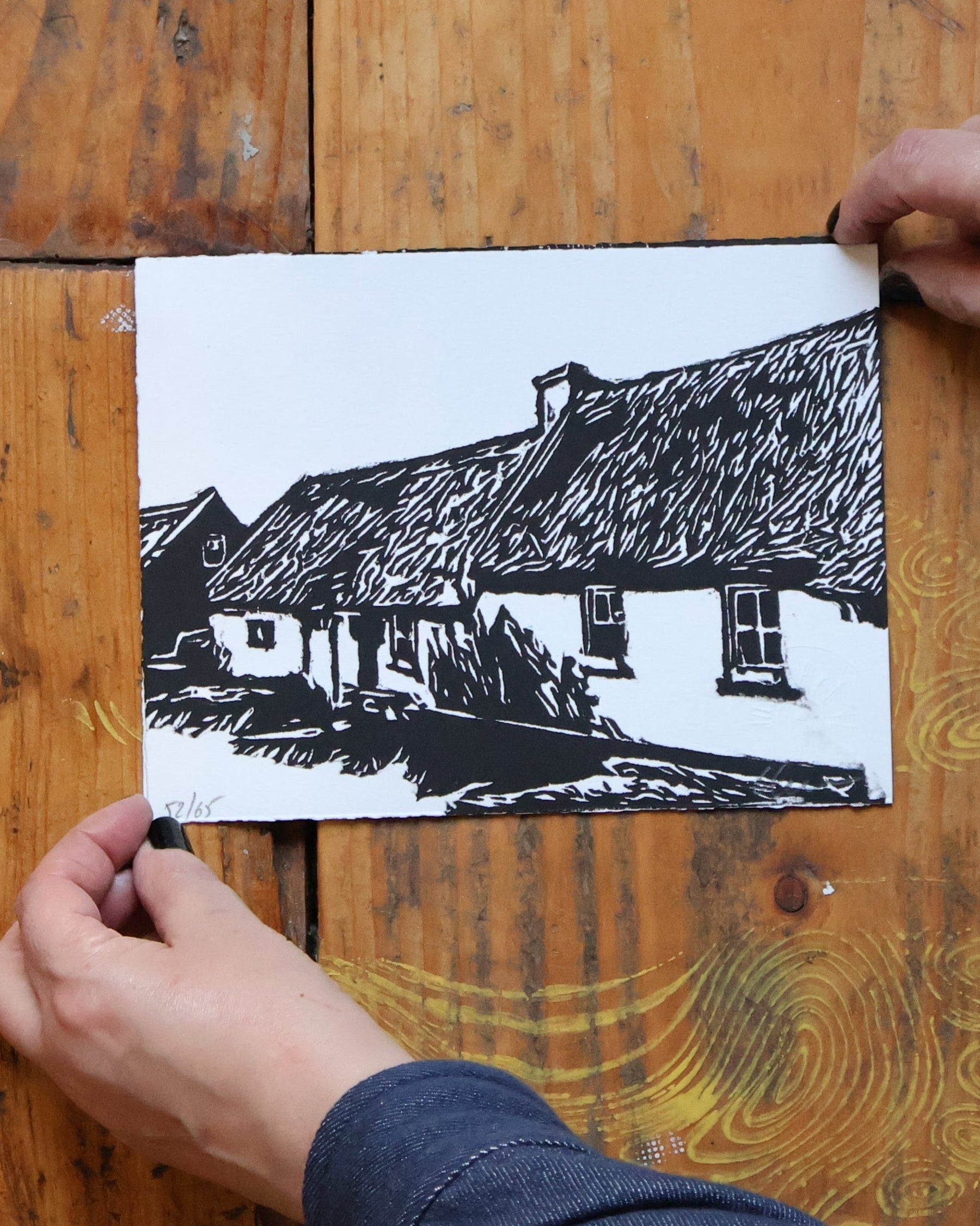 Person holding a black and white photo on a wooden surface