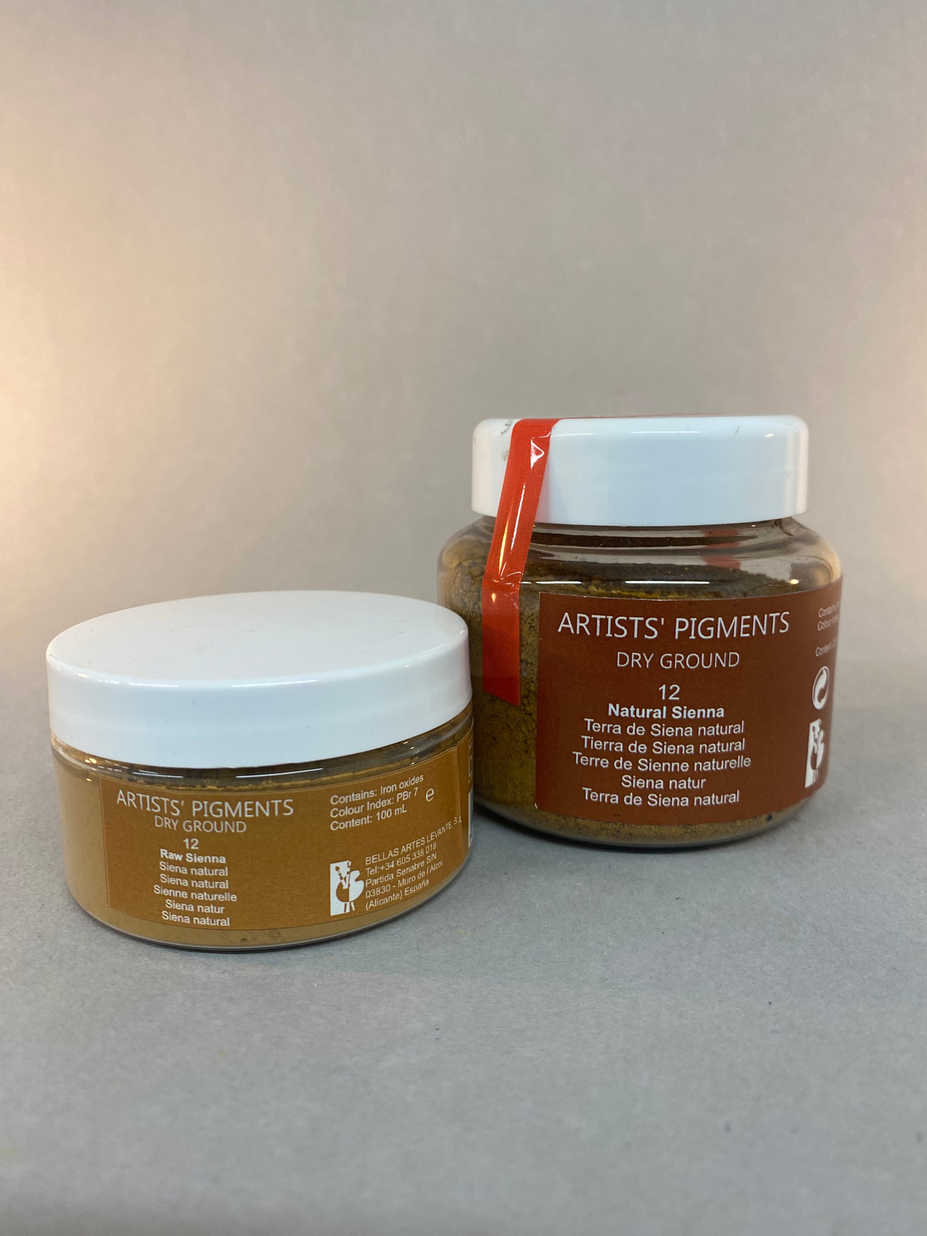 Two jars of Artists Pigments on a gray background