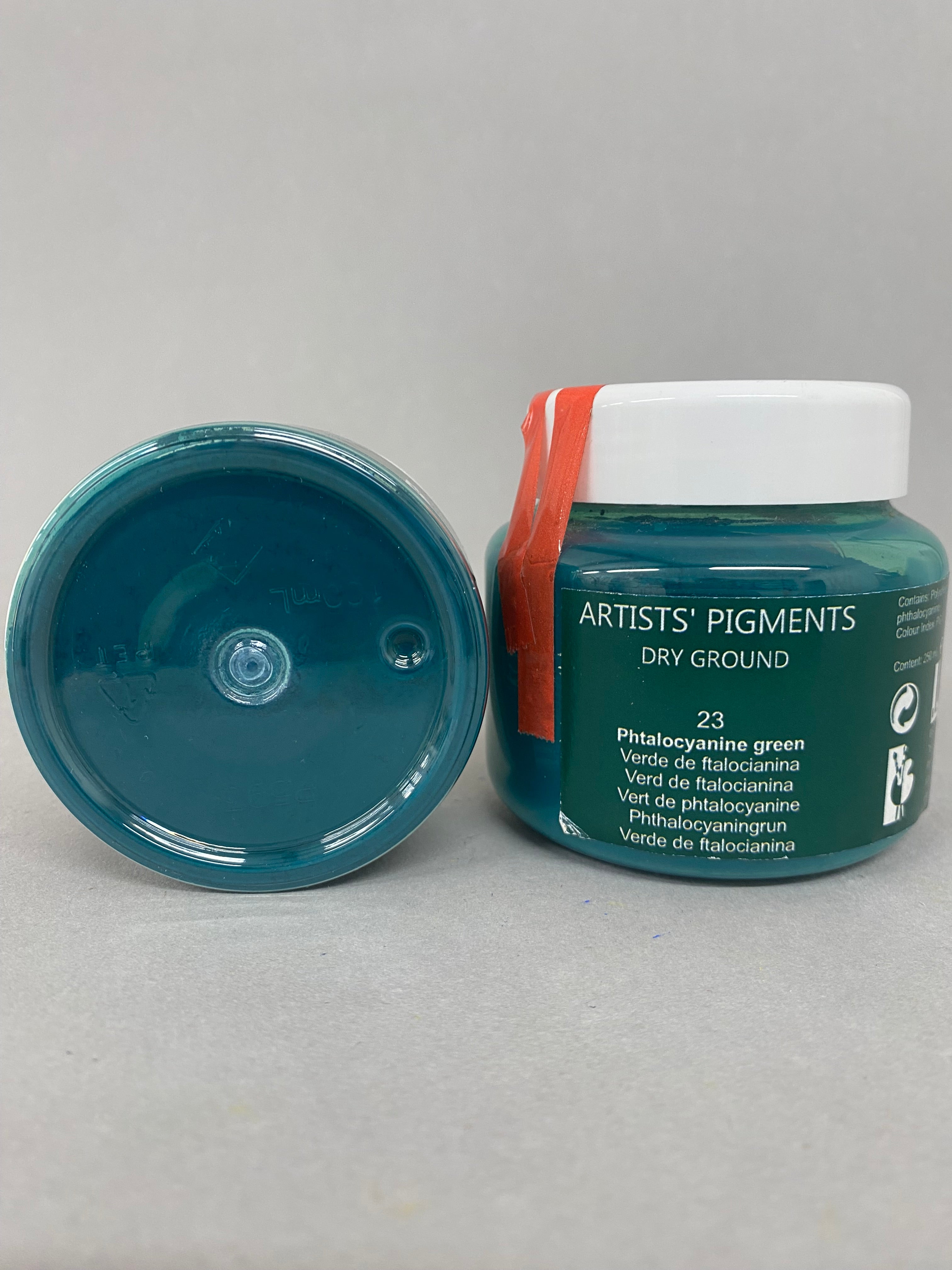 Artists' pigments container with open lid on a gray background