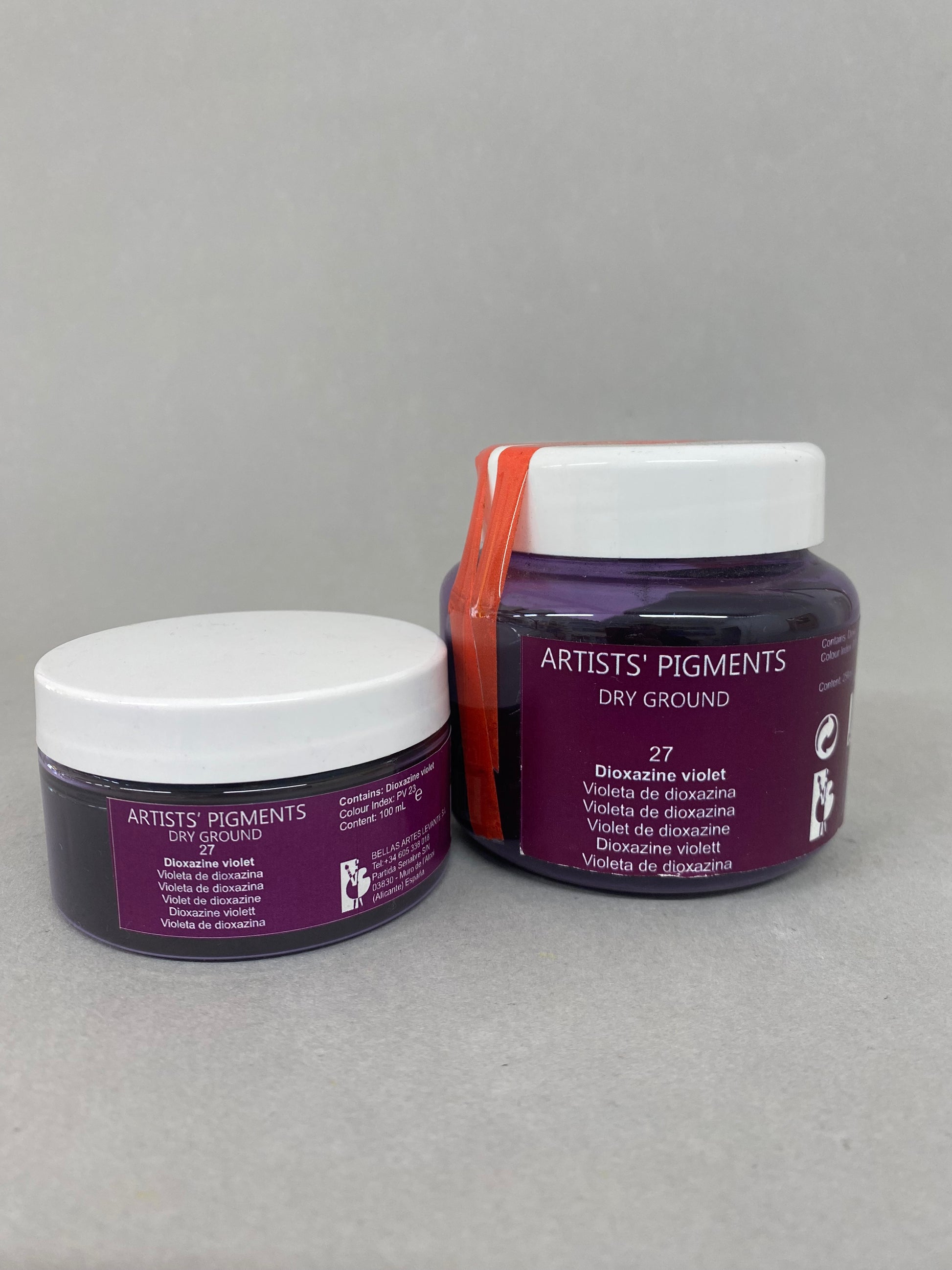 Two containers of 'Artists' Pigments Dry Ground' on a gray background