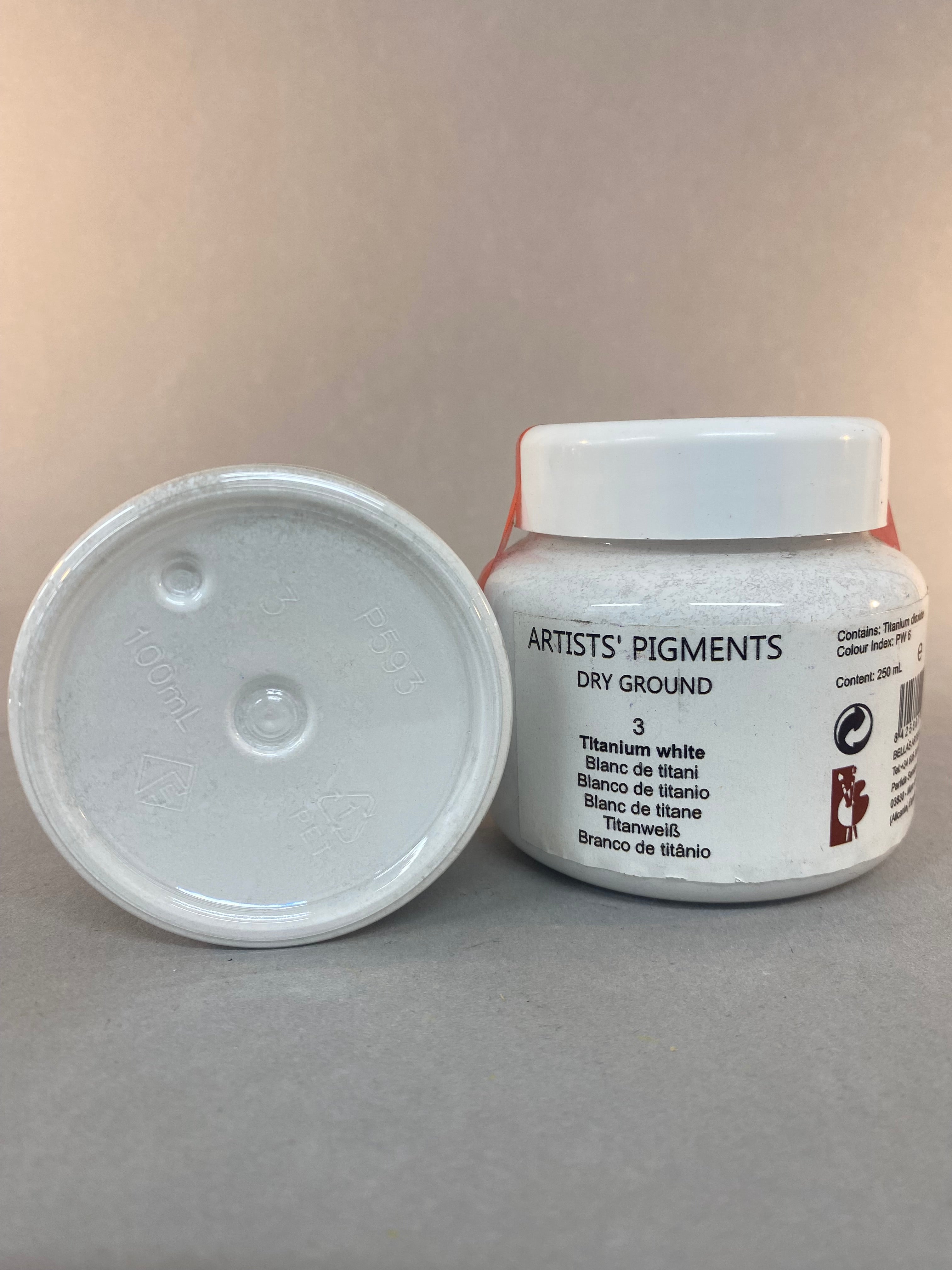 Two containers of artists' pigments on a gray background