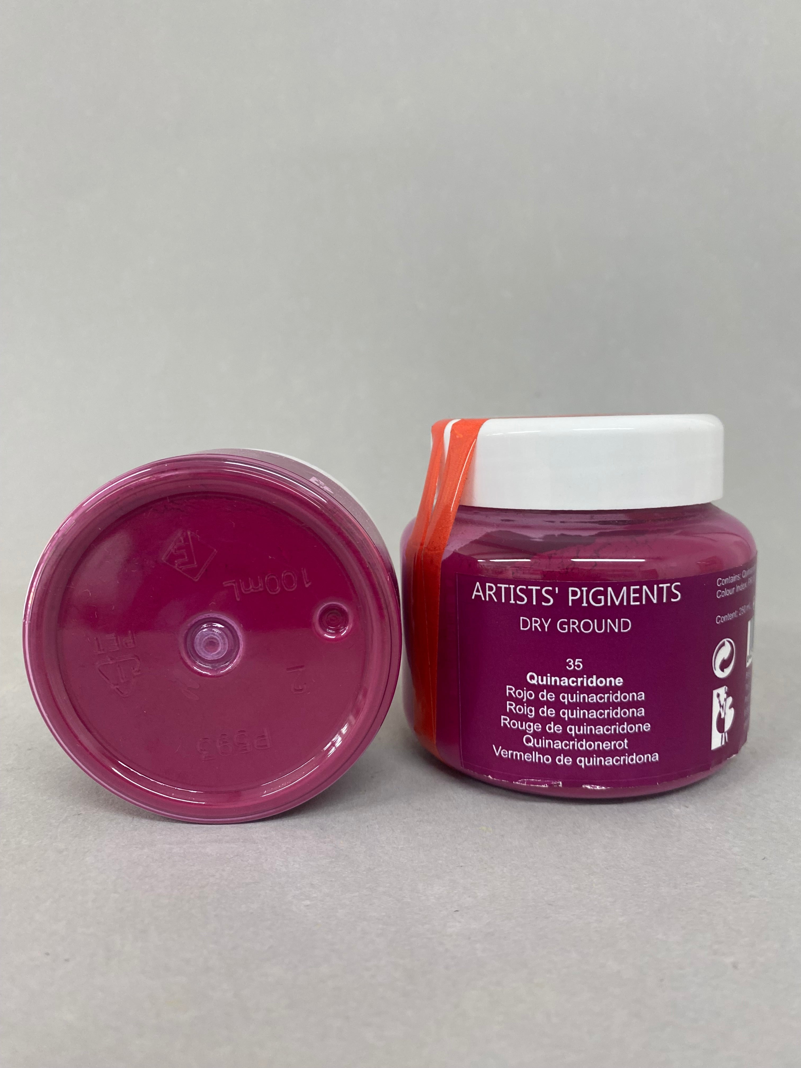 Two containers of 'Artiste's Pigments' on a gray background